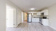 This efficiently designed two-bedroom, one-bathroom unit in Nashville, Tennessee offers a practical single-story layout with consistent, contemporary finishes throughout. Light wood-look vinyl plank flooring runs continuously across every room, creating a cohesive and easy-to-maintain foundation that brightens the interior.

The kitchen serves as a functional centerpiece, featuring white shaker-style cabinetry, granite-look countertops, and a full suite of stainless steel appliances, including a refrigerator, electric range, and built-in microwave. An L-shaped counter configuration maximizes workspace efficiency within the compact footprint.

The living area sits adjacent to the kitchen and receives natural light through a sizable window, with a front entry door providing direct access. Neutral gray walls carry throughout the unit, complementing the light flooring and white trim.

Both bedrooms are modestly sized, each featuring a window that admits natural light and views of surrounding greenery. The unit includes two closets for dedicated storage. The bathroom provides a full tub/shower combination, a white vanity with solid countertop, and matching light flooring, maintaining the unit's clean, neutral aesthetic.