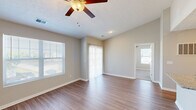 Located at Sapphire Pointe in Beavercreek, Ohio, this two-bedroom, one-bathroom unit offers a well-designed single-floor layout with a practical and comfortable living experience. The living room is a bright, open space featuring durable wood-style flooring, a ceiling fan with light fixture, and multiple windows that invite natural light throughout the day. Sliding glass doors with vertical blinds provide outdoor access and additional light. The kitchen is well-appointed with crisp white shaker-style cabinetry, granite-look countertops, and a full suite of stainless steel appliances including a refrigerator, electric range, and over-the-range microwave. The bathroom features a walk-in shower with built-in shelving, wood-style flooring, and granite countertop detailing. Both bedrooms are carpeted for comfort, with neutral wall tones and natural light from windows with blinds. The primary bedroom is generously sized and includes a walk-in closet outfitted with wire shelving and hanging rods. A second closet provides additional storage. Textured ceilings and clean white trim are consistent throughout the unit, contributing to a tidy and cohesive aesthetic. The entrance leads seamlessly into the main living areas, making the overall layout feel efficient and functional.