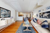 Located at 115 Bridgepoint Dr in Duncan, SC, this single-floor 2-bedroom, 3-bathroom home offers a thoughtfully designed layout that maximizes comfort and functionality. Warm hardwood flooring flows throughout the main living areas, lending continuity and a welcoming ambiance to the entire space.

The expansive open-concept living area serves as the heart of the home, featuring bright white walls, generous ceiling height, and abundant natural light streaming through large windows. The living room flows naturally into a second seating or sitting area, providing flexible use of space. Adjacent to the living room, a combined dining room and kitchen area creates an ideal setup for everyday living and entertaining. The kitchen features warm wood cabinetry, a breakfast bar peninsula, and tile flooring, all seamlessly connected to the dining space accented by a sleek glass shelving unit.

The generously sized primary bedroom includes its own en-suite bathroom and a closet, with hardwood floors and natural light from a well-positioned window. The second bedroom is equally comfortable, also featuring hardwood flooring and a closet. Three full bathrooms, including tub-shower combinations, ensure ample convenience for residents and guests alike. A hallway connects the private quarters, with additional closet storage throughout rounding out this well-organized and inviting home.