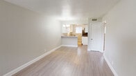 This single-story space offers a thoughtfully updated interior with a cohesive, modern aesthetic carried throughout each room. The living area serves as the heart of the unit, featuring light-toned luxury vinyl plank flooring, a textured ceiling, and a front entry door flanked by a window that draws in natural light. The open layout connects seamlessly to the dining and kitchen areas, unified by a decorative chandelier overhead.

The kitchen is well-appointed with white cabinetry, granite countertops, and a classic subway tile backsplash. A peninsula with additional counter space provides a natural divide between the kitchen and living areas. Black stainless appliances, including a range and refrigerator, complement the overall design, while a window above the sink adds natural light to the workspace.

The bedrooms feature plush wall-to-wall carpeting and ceiling fans with integrated lighting, contributing to a comfortable atmosphere. Each room includes a window with blinds, allowing for adjustable natural light and privacy.

The bathroom is finished with large-format marble-look tile surrounding the tub and shower, a granite-top vanity, and vinyl plank flooring, creating a clean and polished look consistent with the rest of the space.
