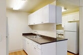 Located at 19701 Crystal Rock Dr in Germantown, MD, this one-bedroom, one-bathroom residence offers a well-organized single-floor layout designed for comfortable everyday living. The open-concept kitchen and living area form the heart of the home, where hardwood-style flooring in the kitchen transitions seamlessly to plush carpeting in the living space. The kitchen is outfitted with white cabinetry, dark countertops, a double sink, and white appliances, providing ample storage and functionality. Crown molding adds a refined touch to the living area, which is bathed in natural light from a large sliding glass door that opens onto a private balcony overlooking a green outdoor setting. The entryway features hardwood-style flooring and a built-in closet, offering convenient storage upon entry. The carpeted bedroom is a comfortable, well-proportioned retreat with a window that brings in natural light and a wall-mounted heating unit for year-round comfort. The bathroom is clean and straightforward, featuring a full tiled tub-shower combination with bright white finishes. Throughout the residence, neutral tones and soft carpeting create a calm and practical living environment suited for a variety of lifestyles.