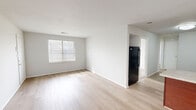 Located at 5313 Justin Ct in Virginia Beach, VA, this two-bedroom, one-bathroom single-floor residence offers a practical and clean layout designed for comfortable everyday living. The open-concept kitchen and living area serves as the heart of the home, featuring light hardwood-style flooring that runs throughout the shared spaces, crisp white walls, and natural light streaming in through slatted blinds. The kitchen is well-appointed with rich dark wood cabinetry, granite-look countertops, a double-basin sink, and a full suite of black appliances including a refrigerator, dishwasher, and range. A peninsula provides added prep space and visually connects the kitchen to the living area. Both bedrooms are carpeted, offering a warm and quiet feel, and each includes a window for natural light and access to closet storage. The two dedicated closets provide practical storage throughout the unit. The bathroom features a full soaking tub with clean white subway tile surround, maintaining the home's consistent, neutral aesthetic. Overall, the space presents a bright, move-in-ready environment with a cohesive design throughout.