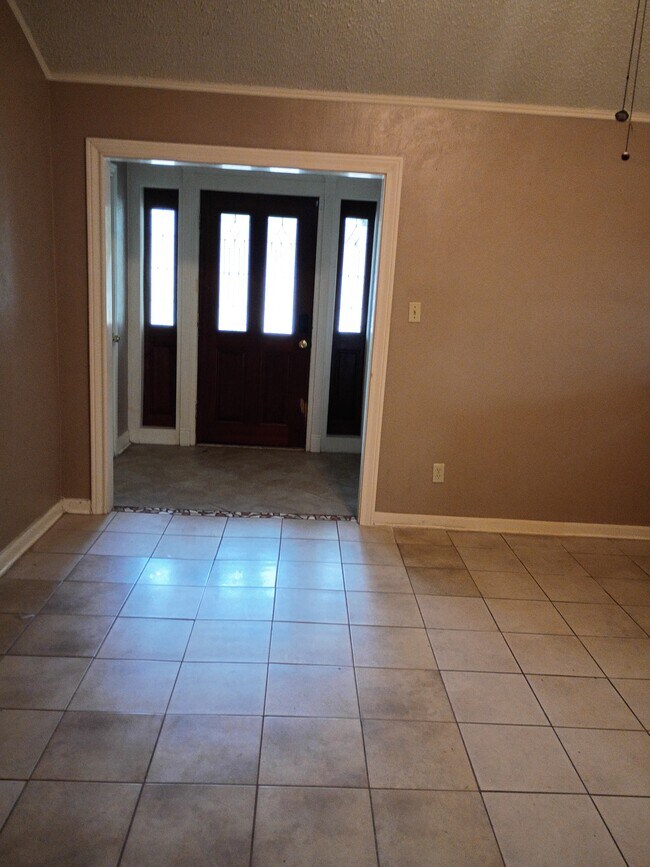 Vista de la sala de estar hacia la puerta principal, habitación 1 a la derecha, trastero a la izquierda - 518 Westshire Dr