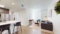 Located at 4343 East Arkansas Avenue in Denver, CO, this well-appointed 2-bedroom, 1-bathroom residence offers a thoughtfully designed single-floor layout with modern finishes throughout. The open-concept living and kitchen area serves as the heart of the home, where light wood-look flooring, crisp white walls, and recessed lighting create a bright, welcoming atmosphere. The kitchen features warm wood cabinetry, stainless steel appliances including a refrigerator, range, and microwave, and a sleek white breakfast bar with seating — ideal for casual dining or entertaining. A skylight overhead adds an extra touch of natural light to the space. The living area flows seamlessly from the kitchen, offering generous room for relaxing, with large windows dressed in vertical blinds that invite natural light. Both bedrooms are carpeted for comfort and include closets for storage. The primary bedroom benefits from a large window and plush, neutral tones, while the second bedroom also features a sizable window and its own closet. The bathroom is finished with wood-look flooring, a modern vanity with dark cabinetry, and a shower. Clean lines and a neutral color palette give the entire residence a cohesive, contemporary feel.