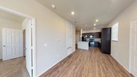 Located at 2811 Oakridge in Lubbock, Texas, this single-story home offers a well-designed, open-concept layout that seamlessly connects the kitchen, dining, and living areas. Rich wood-look flooring flows throughout the main living spaces, creating a warm and cohesive aesthetic.

The kitchen is a standout feature, showcasing dark espresso cabinetry that extends to the ceiling for ample storage, light granite countertops, a full suite of black appliances including a refrigerator, range, and built-in microwave, and a central island with pendant lighting overhead. A window above the sink allows natural light to brighten the workspace.

The open living area is generously proportioned, with a ceiling fan, recessed lighting, and a window that invites additional natural light. A hallway with access to a closet and utility areas connects the main living spaces to the private quarters. The bedrooms feature plush carpeting, ceiling fans, and large windows that fill the rooms with natural light.

The bathroom is clean and functional, featuring a full soaking tub with a shower surround equipped with built-in shelving, complemented by granite countertops and wood-look tile flooring. Throughout the home, neutral tones and consistent finishes create a cohesive and move-in-ready environment.