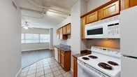 Located at 200 N Harvey Ave in downtown Oklahoma City, this single-floor unit offers an efficient and functional layout with an open feel. The space features industrial-style ceilings with exposed ductwork and piping, lending a loft-like character throughout.

The kitchen is well-appointed with warm oak cabinetry, dark granite-style countertops, a double sink, and a full suite of white appliances including an electric range, over-the-range microwave, dishwasher, and refrigerator. Light ceramic tile flooring runs through the kitchen and transitions seamlessly into the adjoining living area.

The living room is bright and open, benefiting from natural light through large windows fitted with blinds. Track lighting and a ceiling fan add both ambiance and practicality, while light wood-tone laminate flooring gives the room a clean, modern feel.

The bathroom is generously sized for the unit, featuring oak cabinetry, a wide vanity with dark countertops, a large mirror, tile flooring, and a full tub-shower combination. Two closets provide ample storage throughout the unit.

This urban space combines practical finishes with distinctive architectural character, making it a functional and characterful home in the heart of Oklahoma City.