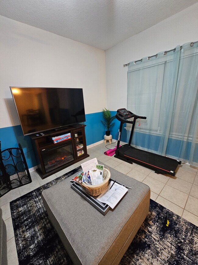 Electric fireplace and treadmill/exercise area by the window during ?? sunrise - 15913 Adam Rd