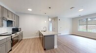 This well-appointed 3-bedroom, 2-bathroom unit in Rochester, MN offers a thoughtfully designed single-floor layout with modern finishes throughout. The open-concept kitchen serves as the heart of the home, featuring gray shaker-style cabinetry, granite countertops, a center island with a built-in sink, subway tile backsplash, stainless steel appliances including a refrigerator and range, and pendant lighting — all flowing seamlessly into the living area. Light wood-tone vinyl flooring runs throughout, creating a cohesive and easy-to-maintain aesthetic. The three bedrooms are generously sized, filled with natural light from large windows, and include access to walk-in closets with wire shelving systems. The primary bedroom offers its own dedicated bathroom with a granite-topped vanity, gray cabinetry, and a walk-in shower. The second bathroom mirrors the same quality finishes with a full shower/tub combination and matching vanity. Additional conveniences include in-unit laundry, a utility room, and ample closet storage with four closets total. Neutral wall tones and clean architectural lines give the space a bright, contemporary ambiance suited for comfortable everyday living.