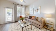 This contemporary apartment at Tapestry Long Farm offers a well-appointed 950 square feet of living space. The open-concept design seamlessly blends the living room, dining area, and kitchen, creating an inviting atmosphere for both relaxation and entertainment. The living room boasts large windows that flood the space with natural light, complemented by a stylish area rug and modern furnishings.

The kitchen is a chef's delight, featuring sleek white cabinetry, stainless steel appliances, and granite countertops. A breakfast bar with wooden stools provides casual seating and additional prep space. The bedrooms, including a 160 square foot primary suite, offer comfort and privacy with plush carpeting and ample closet space. The bathrooms showcase modern fixtures and granite vanities.

Throughout the apartment, neutral tones are accented with pops of color in artwork and decor, creating a harmonious and inviting ambiance. The unit also includes a convenient in-unit laundry area. With its thoughtful design and attention to detail, this apartment offers a perfect blend of style and functionality for modern living.