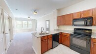 Located at 2701 Neabsco Common Pl in Woodbridge, VA, this 2-bedroom, 2-bathroom unit offers a well-designed, single-floor layout that makes efficient use of its space. The open-concept kitchen is a central highlight, featuring warm cherry wood cabinetry, granite countertops, a peninsula with a built-in sink, and a full suite of black appliances including a range, microwave, dishwasher, and refrigerator. Tile flooring runs throughout the kitchen, while plush carpeting extends into the living area and bedrooms, adding warmth and comfort underfoot. Crown molding in the main living area lends an added touch of elegance.

Both bedrooms are generously proportioned, each equipped with a ceiling fan and neutral-toned walls. The primary bedroom connects to its own bathroom and a spacious walk-in closet with wire shelving. The second bedroom features a window with an outdoor view of surrounding greenery. Each bathroom includes a tub-shower combination with white tile surround, a cherry wood vanity with granite countertop, and tile flooring. A second dedicated walk-in closet provides additional storage. The overall aesthetic is clean, neutral, and move-in ready, offering a comfortable and functional living environment.