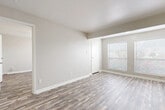This single-story, one-bedroom, one-bathroom unit offers a functional and efficient layout designed to maximize every square foot of living space. The interior is finished with durable wood-look plank flooring that runs consistently throughout, complementing the neutral, warm-toned walls and crisp white trim and doors.

The open living and dining area is bright and welcoming, bathed in natural light from multiple windows fitted with horizontal blinds. A textured ceiling adds subtle visual interest to the living space, while the layout flows naturally into the kitchen area. The front entry opens directly into this shared living space, creating a practical and accessible flow.

The bedroom is a comfortable, well-proportioned room featuring a ceiling fan with a light fixture, a window with outdoor views, and direct access to both a walk-in closet and the bathroom. A second closet provides additional storage, ideal for linens or extra belongings.

The bathroom is clean and functional, featuring a full tub-shower combination with white tile surround, chrome fixtures, and standard vanity. The consistent wood-look flooring carries into the bathroom, tying the unit together with a cohesive design aesthetic. Overall, this unit offers a clean, move-in-ready space with practical features throughout.