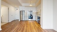 Located at 3030–3060 Pharmacy Ave in Toronto's Scarborough district, this well-appointed 1-bedroom, 2-bathroom unit offers a thoughtfully designed open-concept layout with a clean, contemporary aesthetic throughout. Rich hardwood-style flooring flows seamlessly across the main living area, anchoring the bright, airy atmosphere created by large windows and a sliding glass door that opens to a private balcony.

The kitchen is a functional centerpiece, featuring sleek white cabinetry, a classic subway tile backsplash, and a full suite of stainless steel appliances including a refrigerator, stove, and dishwasher. Track lighting overhead adds a modern touch while illuminating the space effectively.

The bedroom is a comfortable retreat with tall windows that invite generous natural light, complemented by the same warm hardwood-style flooring. A dedicated walk-in closet with wire shelving provides practical storage solutions.

The two bathrooms are finished with floor-to-ceiling white vertical tile. One features a deep soaking tub with tub surround, while the other offers a spacious walk-in shower with a mosaic tile floor and chrome fixtures — both delivering a clean, spa-inspired feel. A hallway connects all areas with ease, completing this efficiently laid-out and stylish urban residence.