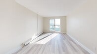 Located at 2311 Ontario St in Oakville, Ontario, this well-appointed one-bedroom, one-bathroom unit offers a thoughtfully designed layout across a single floor. Light-toned hardwood-style flooring flows throughout the main living areas, complementing the neutral, warm wall tones that create a clean and airy ambiance.

The combined kitchen and living area serves as the heart of the unit. The kitchen is outfitted with full-height white shaker cabinetry, dark countertops, a white subway tile backsplash, and a complete suite of stainless steel appliances including a range, over-the-range microwave, and dishwasher. A decorative pendant light and an additional countertop peninsula add both style and functionality.

The living area benefits from a sliding glass door that opens to a balcony, offering expansive water views that fill the space with natural light. Baseboard heating is present throughout.

The bedroom is a comfortable, well-proportioned space featuring two mirrored sliding-door closets, a window with scenic water views, and continued light hardwood flooring. The room receives excellent natural light and offers generous storage.

The bathroom is finished with a clean white subway tile surround enclosing a full soaker tub, paired with polished chrome fixtures for a timeless look.