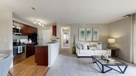 Located at 328 Stratford Pl in Bloomingdale, IL, this single-floor, 2-bedroom, 2-bathroom residence offers a thoughtfully designed layout that maximizes comfort and functionality. The open-concept living, dining, and kitchen area serves as the heart of the home, where hardwood-style flooring transitions seamlessly into plush carpeting in the living room. The living room is bathed in natural light from a sliding glass door that opens onto a private balcony, offering pleasant outdoor views. The galley-style kitchen is outfitted with rich dark wood cabinetry, granite-style countertops, stainless steel appliances, and a breakfast bar that connects to the dining area. The dedicated dining space accommodates a full dining set and adds a distinct sense of structure to the open floor plan. The spacious primary bedroom features ceiling fan, plush carpeting, and a connected bathroom, providing a private retreat. The second bedroom is equally well-proportioned with its own ceiling fan and easy access to the second full bathroom, which includes a tub-shower combination. Two closets offer generous storage throughout. A hallway connects the private quarters to the shared living spaces, creating a natural separation within the home.