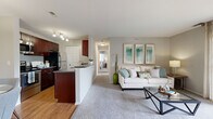 Located at 328 Stratford Pl in Bloomingdale, IL, this single-floor, 2-bedroom, 2-bathroom residence offers a thoughtfully designed layout that maximizes comfort and functionality. The open-concept living, dining, and kitchen area serves as the heart of the home, where hardwood-style flooring transitions seamlessly into plush carpeting in the living room. The living room is bathed in natural light from a sliding glass door that opens onto a private balcony, offering pleasant outdoor views. The galley-style kitchen is outfitted with rich dark wood cabinetry, granite-style countertops, stainless steel appliances, and a breakfast bar that connects to the dining area. The dedicated dining space accommodates a full dining set and adds a distinct sense of structure to the open floor plan. The spacious primary bedroom features ceiling fan, plush carpeting, and a connected bathroom, providing a private retreat. The second bedroom is equally well-proportioned with its own ceiling fan and easy access to the second full bathroom, which includes a tub-shower combination. Two closets offer generous storage throughout. A hallway connects the private quarters to the shared living spaces, creating a natural separation within the home.