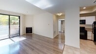 Located at 1400 Midvale Ave in the desirable Westwood neighborhood of Los Angeles, this single-floor unit offers a thoughtfully laid-out living environment with a clean, neutral aesthetic throughout. The living area is highlighted by warm hardwood-style flooring, a classic fireplace, and a skylight that fills the space with natural light, creating an inviting and bright atmosphere. The open flow leads toward a well-organized bedroom featuring the same hardwood-style floors, a sliding glass door that invites natural light, and access to a built-in closet with shelving for ample storage. The kitchen is efficiently designed with tile flooring, granite-style countertops, white cabinetry, and a full suite of black appliances including a gas range, built-in microwave, refrigerator, and dishwasher. A tray ceiling adds a subtle architectural detail overhead. The bathroom is finished with tile flooring, a granite-topped vanity, and a combined shower and bathtub enclosed by sliding glass doors with classic tile surround featuring a decorative accent stripe. The unit's understated, neutral palette and practical finishes make it a functional and comfortable space in a prime Los Angeles location.