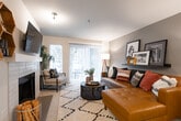 This single-floor residence offers a thoughtfully designed layout that balances comfort and functionality across its key living spaces. The living room serves as the heart of the home, featuring a neutral color palette with a warm gray accent wall, a sliding glass door that fills the room with natural light, and access to an outdoor area. The dining area is adjacent to the living space and features a ceiling fan, decorative wall accents, and an octagonal mirror above a sideboard, creating an inviting atmosphere for gatherings. The galley-style kitchen is equipped with light wood cabinetry, white countertops, stainless steel appliances including a refrigerator, electric range, and built-in microwave, complemented by wood-look flooring. The primary bedroom benefits from multiple windows that bring in ample natural light and features plush carpeting and a calm, neutral aesthetic. A second bedroom offers a versatile layout suitable as a child's room or home office, also with carpeting and a bright window. Both bathrooms are finished with wood-look flooring, light cabinetry with white countertops, and tub-shower combinations. A utility area with an in-unit washer and water heater provides added convenience. Throughout, the space maintains a cohesive, modern design with warm tones and practical finishes.