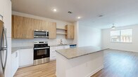 Located at 1296 Moreland Ave SE in Atlanta, GA, this 1-bedroom, 1-bathroom unit offers a thoughtfully designed single-floor layout with a clean, contemporary aesthetic throughout. Light hardwood-style flooring runs continuously across all rooms, creating a cohesive and bright atmosphere.

The open-concept kitchen and living area serves as the heart of the unit. The kitchen is well-appointed with stainless steel appliances — including a range, microwave, and dishwasher — complemented by two-tone cabinetry featuring warm wood upper cabinets paired with crisp white lower cabinets. A white subway tile backsplash adds texture, while the granite-topped center island provides additional prep space and a natural gathering point between the kitchen and living area.

The bedroom is a comfortable, well-proportioned room featuring a ceiling fan, a window with natural light and neighborhood views, and direct access to the bathroom. The bathroom continues the granite countertop theme with white cabinetry, offering a clean and functional design. A walk-in closet with wire shelving provides organized storage, and a dedicated laundry area adds everyday convenience. Recessed lighting throughout the unit contributes to a polished, modern finish.