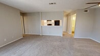 This single-story, 2-bedroom, 2-bathroom residence offers a functional and well-organized layout designed for comfortable everyday living. The open-concept main living area seamlessly connects the living room, dining area, and kitchen. The living room is a standout space, featuring a wood-burning fireplace framed by a clean white mantle, plush carpeting, and multiple windows fitted with horizontal blinds that allow ample natural light to fill the room. The kitchen is outfitted with white cabinetry, speckled stone countertops, black appliances including a range with overhead ventilation and a full-size refrigerator, and durable wood-look flooring. A pass-through counter connects the kitchen to the living and dining area, enhancing the open feel. The primary bedroom offers generous proportions, carpeted flooring, sliding glass door access with vertical blinds, and an expansive walk-in closet with built-in shelving and hanging rods. The second bedroom features carpet, a ceiling fan with light, a window for natural light, and a sliding-door closet. Both bathrooms are finished with wood-look flooring, while the primary bath includes a wide vanity with dual sinks, a large mirror, and ample cabinet storage. Additional highlights include a laundry area, a pantry, and multiple closets throughout for plentiful storage. Textured ceilings are consistent throughout the home.
