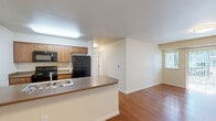 Located at 2401 NE Four Seasons Lane in Vancouver, WA, this single-floor, 3-bedroom, 2-bathroom home offers a well-organized and functional layout. The living room is bright and welcoming, featuring warm hardwood-style flooring, neutral walls, and sliding glass doors that open to a private patio, allowing natural light to fill the space and providing easy outdoor access.

The kitchen and dining area share an open-concept design, anchored by a peninsula counter with a built-in sink. The kitchen is equipped with wood-toned cabinetry, black appliances including a refrigerator, range, and over-the-range microwave, and offers convenient sight lines into the dining and living areas. A dedicated pantry adds valuable storage.

A central hallway connects the three bedrooms, each carpeted and fitted with windows that invite natural light. The primary bedroom is a comfortable size, offering ample space for furnishings. The two bathrooms are well-appointed with warm wood vanities, large mirrors with overhead lighting, and tile surrounds. One bathroom includes a full soaking tub and shower combination. The home also includes a laundry area, three closets, and hardwood-style flooring throughout the main living zones, completing this practical and comfortable residence.
