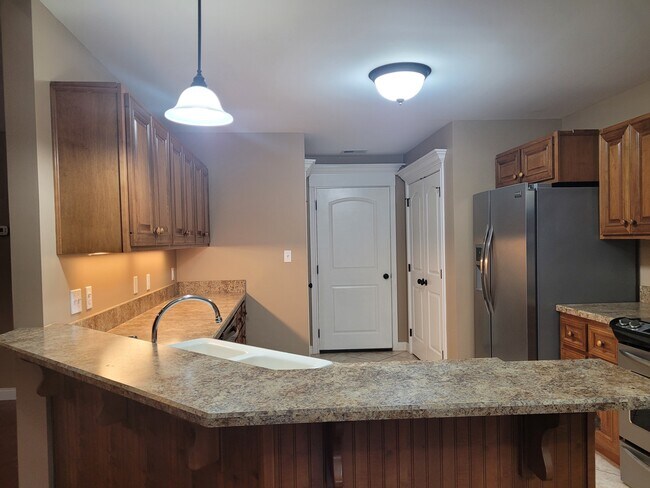 Cocina abierta con estufa eléctrica de acero inoxidable, lavavajillas, refrigerador y microondas. - 528 N 2nd St