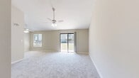 Located at 7503 Gavilan Ct in North Chesterfield, VA, this three-bedroom, two-bathroom residence offers a well-designed single-floor layout with a welcoming entrance. The living area immediately impresses with soaring vaulted ceilings and a ceiling fan, creating an airy, open atmosphere. Soft carpeting flows throughout the living and bedroom spaces, complementing the neutral, warm-toned walls.

The galley-style kitchen is well-appointed with crisp white shaker cabinets extending to the ceiling, granite countertops, stainless steel appliances, and wood-look flooring — providing both style and functionality. A convenient in-unit stacked washer and dryer is tucked just off the main living area.

Each of the three bedrooms features plush carpeting and ceiling fans with light fixtures. The bedrooms offer ample closet space, including sliding panel closets, and windows that invite natural light and outdoor views of the surrounding greenery. The primary bedroom is a comfortable, well-proportioned retreat.

The two bathrooms are cleanly finished — one features a vanity with granite countertops, wood-look flooring, and a tub/shower combo, while the second includes a walk-in shower. A private balcony off the main living area overlooks a lush, open communal lawn with mature trees, offering a peaceful outdoor setting.