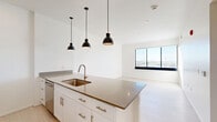 This contemporary 560 square foot apartment in Tucson, Arizona, offers a harmonious blend of style and functionality. The heart of the home is an open-concept living area, anchored by a modern kitchen. White cabinetry contrasts beautifully with stainless steel appliances, while a large island with a sink provides ample prep space and casual dining options. Three pendant lights add a touch of industrial chic.

The spacious bedroom, measuring 140 square feet, features a large window that floods the space with natural light and offers scenic views. The bathroom is clean and crisp, with white tiles, a shower/tub combination, and bronze fixtures for a warm accent.

Convenience is key with an in-unit laundry area, equipped with full-sized washer and dryer. Throughout the apartment, light wood flooring creates a sense of continuity and enhances the overall bright, airy feel. The neutral color palette and minimalist design allow for personal touches and flexible decorating options. This well-designed space maximizes every square foot, offering comfortable urban living in a prime Tucson location.