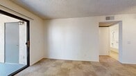 Located at 10406 Indiana Ave in Riverside, CA, this single-floor, 2-bedroom, 1-bathroom unit offers a practical and efficient layout. The entrance leads into a well-organized floor plan that maximizes every inch of available space.

The kitchen is a standout feature, equipped with light wood cabinetry, a white electric range, refrigerator, and a sink set into a countertop with a breakfast bar-style divider. A skylight overhead fills the kitchen with natural light, enhancing its warm, functional ambiance. Tile flooring completes the space.

Both bedrooms are carpeted and finished with neutral tones, textured ceilings, and wall-mounted air conditioning units. Each room features windows with vertical blinds that allow natural light while maintaining privacy. The primary bedroom offers a comfortable footprint, while the secondary bedroom includes a closet for added storage.

The bathroom is clean and efficiently designed, featuring tile flooring, a full bathtub with a handheld showerhead, safety grab bars, and light wood-toned cabinetry on the door. White walls and neutral finishes maintain a bright, tidy aesthetic throughout.

Overall, this unit presents a straightforward, no-frills living space with consistent neutral tones, practical finishes, and a clear, easy-to-navigate layout suited for everyday living.