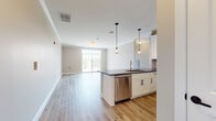 This well-designed single-floor residence offers a bright, open-concept layout that seamlessly connects the kitchen, dining, and living areas. Light hardwood flooring flows throughout the main living spaces, complementing the neutral warm-toned walls and crisp white trim.

The kitchen is a standout feature, equipped with white shaker-style cabinetry, dark countertops, a classic subway tile backsplash, and a full suite of stainless steel appliances including a gas range, built-in microwave, refrigerator, and dishwasher. Elegant pendant lighting hangs above the peninsula, which provides additional prep space and casual seating.

The generously sized living area benefits from abundant natural light through large windows and sliding glass doors that open to a private balcony with scenic outdoor views. The bedrooms are well-proportioned, each bathed in natural light from large windows.

The primary bathroom features a dual-sink vanity with dark countertops, white cabinetry, and a glass-enclosed shower with tile surround. The secondary bathroom offers a single-sink vanity with a white countertop and a tub-shower combination adorned with striking marble-style tile on both the walls and floor, adding an elevated touch to the space.