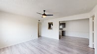 Located at 7114 Texas Rd in Fort Smith, Arkansas, this single-floor, 3-bedroom, 2-bathroom home offers a practical and well-organized layout. The open living room is bright and airy, featuring light-toned luxury vinyl plank flooring, a textured ceiling, and a ceiling fan with a built-in light fixture. A pass-through window connects the living area to the kitchen, creating an open and connected feel throughout the common spaces.

The kitchen is well-appointed with dark cabinetry, light speckled countertops, a double-basin sink with a matte black faucet, pendant lighting, and white appliances including a refrigerator, range, microwave, and dishwasher. Ample cabinet storage lines both sides of the galley-style kitchen, maximizing functionality.

The three bedrooms are finished with the same LVP flooring and feature neutral walls and slatted windows that allow natural light to filter in. The primary bedroom offers a compact yet efficient footprint. Both bathrooms include a tub-shower combination, a vanity with dark cabinetry and light countertops, and LVP flooring. A hallway and closet round out the floor plan, providing additional storage and connectivity between rooms.