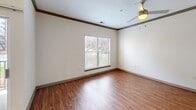 Located at 4915 Shadow Oaks Dr in Charlotte, NC, this 2-bedroom, 2-bathroom single-floor residence offers a well-designed layout that balances comfort and functionality. The open living room features warm hardwood-style flooring, crown molding, recessed lighting, and a ceiling fan, with natural light entering through large windows fitted with blinds. The kitchen is equipped with rich wood cabinetry, dark granite-style countertops, a striking mosaic tile backsplash, and stainless steel appliances, including a full-size refrigerator. Both bedrooms are carpeted and include ceiling fans and windows that bring in natural light. The primary bedroom offers a notably generous footprint with closet access visible from the room. The secondary bedroom similarly features multiple windows and plush carpet. Both bathrooms are finished with hardwood-style flooring, warm wood vanities, and dark countertops. The full bathroom includes a tiled shower-tub combination and well-lit vanity mirror. A hallway connects the bedrooms and bathrooms, contributing to an efficient and cohesive floor plan throughout the home.
