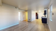 Located at 3240 13th St SE in Washington, DC, this two-bedroom, one-bathroom residence offers a practical and well-maintained single-floor layout. Light wood-style flooring runs consistently throughout the unit, creating a cohesive and bright feel across all rooms.

The open living area flows naturally toward the kitchen, which is equipped with rich dark wood cabinetry, a gas range, black refrigerator, and a built-in breakfast bar with a light stone-style countertop. A window in the kitchen provides natural light and ventilation.

Both bedrooms are comfortably sized with neutral wall tones, light flooring, and windows that allow natural light to filter in. The primary bedroom features a sliding mirrored closet door, adding both storage and visual depth to the space. The second bedroom also includes closet access and a window with blinds.

The bathroom is cleanly finished with tile flooring, a wall-mounted vanity with a white basin, a large mirror, and a tub-shower combination equipped with grab bars and a built-in seat, reflecting an accessible design.

A central hallway connects all rooms efficiently, and the unit includes visible HVAC vents throughout. The overall aesthetic is clean, functional, and move-in ready, suited for everyday living in Southeast Washington.