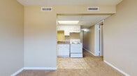 Located at 508 Heather Ln in Newton, Kansas, this single-floor unit offers a straightforward, functional layout designed for comfortable everyday living. The interior is finished with neutral warm beige tones throughout, creating a cohesive and understated aesthetic across all rooms.

The kitchen is efficiently arranged, featuring white cabinetry both above and below the counters, dark laminate countertops, a double-basin sink, a white electric range, and a full-size refrigerator. Tile-style flooring grounds the kitchen space, and a drop ceiling with a built-in light panel provides steady overhead illumination. The kitchen opens directly to the adjacent living area, which transitions to wall-to-wall carpet and offers a practical, open feel.

The living area is generously sized with neutral carpeting, warm-toned walls, and multiple electrical outlets, providing flexibility for furniture arrangement. Windows along one wall allow natural light to enter the space.

The bedroom is a calm, carpeted room featuring a bi-fold closet for storage and clean, simple walls. The bathroom includes a full tub and shower unit with a white surround panel system and built-in shelving niches, alongside a toilet. The overall ambiance of the unit is clean, practical, and move-in ready.