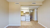 Located at 508 Heather Ln in Newton, Kansas, this single-floor unit offers a straightforward, functional layout designed for comfortable everyday living. The interior is finished with neutral warm beige tones throughout, creating a cohesive and understated aesthetic across all rooms.

The kitchen is efficiently arranged, featuring white cabinetry both above and below the counters, dark laminate countertops, a double-basin sink, a white electric range, and a full-size refrigerator. Tile-style flooring grounds the kitchen space, and a drop ceiling with a built-in light panel provides steady overhead illumination. The kitchen opens directly to the adjacent living area, which transitions to wall-to-wall carpet and offers a practical, open feel.

The living area is generously sized with neutral carpeting, warm-toned walls, and multiple electrical outlets, providing flexibility for furniture arrangement. Windows along one wall allow natural light to enter the space.

The bedroom is a calm, carpeted room featuring a bi-fold closet for storage and clean, simple walls. The bathroom includes a full tub and shower unit with a white surround panel system and built-in shelving niches, alongside a toilet. The overall ambiance of the unit is clean, practical, and move-in ready.