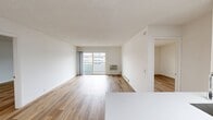 Located at 1970 E 16th St in Newport Beach, CA, this 850-square-foot single-floor unit offers 2 bedrooms, 1 bathroom, a living room, and a kitchen. Throughout the unit, light wood laminate flooring creates a clean, cohesive aesthetic against white walls. The spacious living room features a sliding glass door that opens to a private balcony with views of the surrounding complex and a tennis court, while baseboard heating and a wall A/C unit provide year-round climate control. The updated kitchen is equipped with modern light wood cabinetry, white countertops, stainless steel appliances including an electric range, dishwasher, and refrigerator, complemented by a tile backsplash. The primary bedroom spans 260 square feet and includes a mirrored sliding closet, recessed lighting, and ample space. The second bedroom features a window with natural light and its own baseboard heater. The bathroom offers a full shower-tub combination with chrome fixtures. Clean, neutral finishes and an abundance of natural light throughout make this unit a bright and functional home in the heart of Newport Beach.