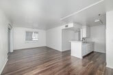 Located at 14630 Wyandotte St, this 2-bedroom, 1-bathroom unit is thoughtfully laid out across a single floor, offering a practical and comfortable living arrangement. Hardwood-style flooring runs throughout the home, with rich dark tones in the living, kitchen, hallway, and bathroom areas, and warm honey-toned wood in both bedrooms, creating a distinct yet cohesive aesthetic.

The combined kitchen and living room serves as the central hub of the unit. The kitchen features white cabinetry, a gas range, and a full-size refrigerator, all set against dark hardwood-style floors. The living area is bright and open, with a sliding glass door fitted with a decorative laser-cut privacy screen that leads directly to a private balcony — a functional outdoor extension ideal for fresh air and natural light.

Both bedrooms are well-sized, with the primary bedroom offering generous proportions and vertical-blind windows that invite ample natural light. The second bedroom also benefits from a large window with vertical blinds and warm hardwood-style flooring. The bathroom includes a full-size soaking tub and shower combination with clean white surrounds, accessed via a hallway that connects the private areas of the unit. A dedicated hallway provides logical flow between all rooms.