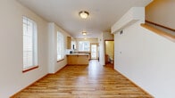 Located at Water Lily Loop in Bellingham, WA, this two-bedroom, two-bathroom residence is arranged across two floors, offering a practical and well-organized layout. The main floor features a combined kitchen and living area anchored by light hardwood flooring throughout. The kitchen is equipped with light maple cabinetry extending to the ceiling, stone-toned countertops, black appliances including a range and over-the-range microwave, and a peninsula with seating overhang. A window above the sink provides natural light, and a door leads to an exterior balcony. The living area benefits from large windows that bring in additional daylight, with a staircase along one wall leading to the upper floor.

Upstairs, both bedrooms feature neutral carpet, ample closet space with sliding or hinged doors, and windows allowing natural light. The primary bedroom includes a double sliding closet. Each bathroom is finished with tile flooring, wood-toned vanity cabinetry, stone-look countertops, and a tub-shower combination. The overall interior maintains a clean, neutral palette with warm wood accents and white trim throughout, creating a consistent and cohesive aesthetic.