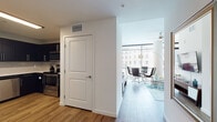 Located in the heart of downtown Orlando, this contemporary residence at 355 N Rosalind Ave offers a thoughtfully designed single-floor layout with modern finishes and an open, airy ambiance. The living and dining area is a standout feature, boasting expansive floor-to-ceiling windows that wrap the corner of the space, flooding the interior with natural light and offering sweeping urban views. A ceiling fan and smooth white ceilings complement the clean aesthetic, while wood-style flooring runs throughout the main living areas. The kitchen is outfitted with sleek dark cabinetry, light countertops, stainless steel appliances including a range, microwave, and dishwasher, and a tile backsplash — providing a functional and stylish cooking space. The bedrooms are carpeted for comfort, with large windows that invite natural light and cityscape views. The bathroom features wood-look flooring, a tub-shower combination, and dark vanity cabinetry with clean white countertops, maintaining the modern design language found throughout the residence. The overall atmosphere is polished and contemporary, well-suited for urban living in one of Orlando's most accessible downtown locations.