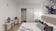 Located in the vibrant Koreatown neighborhood of Los Angeles, this single-floor residence at 800 S Harvard Blvd offers a thoughtfully designed living space with modern finishes throughout. Light wood-style flooring flows seamlessly across the open layout, connecting each area with a cohesive, contemporary aesthetic.

The kitchen is a standout feature, boasting two-tone cabinetry that pairs warm wood lower cabinets with sleek white upper cabinets, all complemented by a distinctive hexagonal tile backsplash and clean white countertops. Stainless steel appliances — including a refrigerator, range, microwave, and dishwasher — complete this functional and stylish culinary space. A dining area sits adjacent, offering an inviting setting for everyday meals.

The bedrooms are bright and well-proportioned, each featuring light-filled windows and light wood flooring. One bedroom includes a spacious built-in closet with sliding doors, offering ample shelving and hanging storage. A second bedroom provides a similarly airy and comfortable environment.

The bathroom is finished with large-format floor tiles, vertical subway tile surrounding the soaking tub and shower, and a warm wood vanity topped with a white sink basin and an illuminated mirror — a clean and refined design.

A wide hallway connects the spaces, with an arched mirror detail adding architectural character. Recessed lighting and HVAC vents throughout ensure year-round comfort in this well-appointed Los Angeles residence.