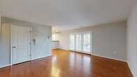 Located at 1420 Southern Ridge Dr in Charlottesville, VA, this single-floor home offers four bedrooms, two bathrooms, and four closets across a efficiently organized layout. The open-concept living, dining, and kitchen area serves as the heart of the home, featuring rich hardwood flooring that extends throughout the main living spaces. French doors along the exterior wall allow natural light to fill the living room and provide outdoor views, enhancing the sense of openness. The kitchen is well-appointed with warm-toned wood cabinetry, dark countertops, recessed lighting, a peninsula with a breakfast bar, and black appliances including a range, microwave, and dishwasher. A stainless steel side-by-side refrigerator with an ice and water dispenser completes the kitchen. The bedrooms are carpeted for comfort, each featuring ceiling fans with light fixtures and windows that bring in natural light. The primary bedroom includes its own closet and door access for added privacy. The two bathrooms offer clean, functional designs — one featuring a soaking tub and shower combination, and the other a standalone shower unit with built-in shelving. Neutral tones, white panel doors, and consistent finishes throughout give the home a cohesive and move-in-ready appearance.