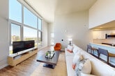 Located at 888 4th Street in Santa Rosa, CA, this thoughtfully designed 2-bedroom, 2-bathroom residence offers a bright and modern living experience across a single floor. The open-concept layout seamlessly connects the living room, dining area, and kitchen, creating an inviting and functional space. The living room is a standout feature, boasting dramatic floor-to-ceiling windows that flood the interior with natural light and frame sweeping outdoor views of the surrounding cityscape and hills. Soaring ceilings amplify the sense of openness throughout the main living area.

The kitchen is outfitted with stainless steel appliances, including a range, microwave, and dishwasher, complemented by two-tone cabinetry in white and gray, and sleek light-colored countertops with an undermount sink. Wood-style flooring runs throughout the home, adding warmth and continuity.

The generously sized primary bedroom features a sliding closet and direct access to a private bathroom equipped with a walk-in shower with large-format white tile surround. The second bedroom is well-proportioned, bright, and served by a full bathroom with a tub-shower combination and tile flooring. Both bedrooms include closets for ample storage. A dedicated laundry area completes this well-appointed home.