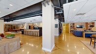 Located at 5863 Arapahoe Avenue in Boulder, Colorado, this thoughtfully designed single-floor commercial space offers a generous and versatile layout ideal for collaborative work and community gathering. Polished concrete floors flow throughout, reflecting light and lending a cohesive, industrial-chic aesthetic to the entire space.

The open-plan common area serves as the heart of the floor, featuring multiple distinct lounge zones furnished with plush sectional sofas, leather armchairs, and curated décor. Built-in wood cabinetry with integrated shelving and a wall-mounted TV anchor one lounge area, while large glass garage-style doors in another zone connect the interior to the outdoors, flooding the space with natural light and outdoor views.

A welcoming reception lobby greets visitors with comfortable leather seating arranged over a vibrant area rug, framed by floor-to-ceiling windows that bring in ample daylight. Adjacent to this is a well-appointed conference room featuring a solid wood table, leather chairs, a wall-mounted display, and a large window overlooking the exterior.

The kitchen and bar area is a standout feature, outfitted with light wood cabinetry, a stainless steel refrigerator, a metal-topped island, and a long bar with industrial-style seating. Exposed ductwork and structural elements on the ceiling add an authentic industrial character throughout, balancing the warm, inviting furnishings across the space.