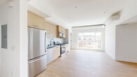Located at 611 N Virgil Avenue in Los Angeles, this thoughtfully designed residence offers three bedrooms and three bathrooms across a single floor. The open-concept living and kitchen area serves as the heart of the home, where light wood-tone cabinetry, dark stone countertops, a white subway tile backsplash, and a full suite of stainless steel appliances — including a gas range, dishwasher, microwave, and refrigerator — create a clean, contemporary aesthetic. Light hardwood flooring flows seamlessly throughout the living spaces and bedrooms, enhancing the bright, airy feel. Large picture windows in the living area and bedrooms flood the interior with natural light while framing views of the surrounding Los Angeles neighborhood. The bedrooms are well-proportioned, featuring crisp white walls, light wood floors, and generous closet space. Each of the three bathrooms is appointed with striking floor-to-ceiling green subway tile in the walk-in glass showers, terrazzo tile flooring, and warm wood vanities accented by matte black hardware — a cohesive and stylish design touch. Exposed ductwork and architectural ceiling details in the living area add an industrial-modern character to the overall aesthetic, making this a well-appointed home in a vibrant Los Angeles location.