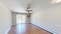 Located at 3401 Bristol-Oxford Valley Road in Levittown, PA, this one-bedroom, one-bathroom unit offers a practical and comfortable single-floor layout. Warm hardwood-style flooring runs throughout the space, lending a cohesive and inviting feel to every room.

The living room is a bright, open area featuring a ceiling fan with light fixture, a wall-mounted air conditioning unit, and baseboard heating along the perimeter — ensuring year-round comfort. Neutral gray walls keep the space feeling clean and versatile.

The bedroom is a well-proportioned retreat with ample natural light from a window fitted with blinds, a wall air conditioning unit, and baseboard heating. A closet provides convenient storage, and the room receives generous sunlight that highlights the warm flooring tones.

The kitchen is efficiently designed with wooden cabinetry, granite-style countertops, and stainless steel appliances including an electric range, over-the-range microwave, and refrigerator — providing all the essentials in a compact, functional layout.

The bathroom features a clean, tiled tub-shower combination with white subway-style wall tiles, offering a simple and well-maintained space.

A sliding glass door opens to a private balcony with outdoor views, adding a pleasant extension to the living area. The overall ambiance is clean, functional, and move-in ready.