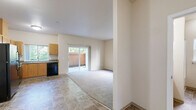 Located at 675 White Oak Cir in Independence, Oregon, this single-story, one-bedroom, two-bathroom home offers a practical and comfortable layout. The open-concept living and kitchen area is bright and welcoming, with large sliding glass doors leading to a private patio enclosed by a wood fence and surrounded by mature, leafy trees — creating a peaceful outdoor retreat. The kitchen is well-equipped with light maple cabinetry, black appliances including a refrigerator, electric range, microwave, and dishwasher, complemented by stone-look tile flooring and a window above the sink that brings in natural light. The living area transitions seamlessly from tile to plush carpeting and features multiple windows that fill the space with greenery views. The spacious bedroom is carpeted and includes a wide sliding-door closet and dual windows that offer views of the surrounding landscape. A dedicated laundry area with a full-size washer and dryer adds convenience. Both bathrooms feature stone-look tile flooring; one includes a full tub-shower combination with a frosted privacy window. Neutral, warm-toned walls throughout lend a clean, cohesive feel to the entire home.