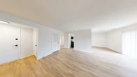 Located at 1803 Cobourg Ct in Parkville, MD, this two-bedroom, one-bathroom single-story home offers a well-organized and functional layout with clean, modern finishes throughout. The open-concept living and dining area is anchored by light-toned hardwood-style flooring and bright white walls, creating an airy and welcoming atmosphere. A louvered interior door adds a classic touch while maintaining the home's crisp aesthetic.

The kitchen is a standout feature, showcasing white shaker-style cabinetry with matte black hardware, marble-look countertops, a stainless steel sink with a black faucet, and stainless steel appliances including a range, over-the-range microwave, and dishwasher. The space is efficiently laid out and connects seamlessly to the rest of the home.

Both bedrooms are carpeted for comfort. The spacious primary bedroom includes dual closets with sliding and bi-fold doors, offering generous storage. The second bedroom is cozy and well-proportioned. The full bathroom features a tub/shower combo surrounded by classic blue-grey subway tile and includes a window for natural light. A central hallway connects the living spaces to the bedrooms, providing a logical and comfortable flow throughout the home.