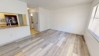 This 560 square foot apartment in Ocala, Florida, offers a surprising amount of space and functionality within its compact layout. The home features two bedrooms, including a spacious primary bedroom of 310 square feet, and one bathroom. Throughout the apartment, modern gray wood-look flooring creates a cohesive and contemporary aesthetic. The living areas are characterized by an open concept design, enhancing the sense of space. Large windows and sliding glass doors flood the rooms with natural light, while vertical blinds offer privacy control. The kitchen, while not fully visible in the images, appears to be integrated into the main living space, promoting a fluid layout. The bathroom is outfitted with essential fixtures and beige tiled flooring, with safety features such as grab bars. Ceiling fans in the bedrooms and living area provide air circulation. The apartment's neutral color palette, predominantly white walls, and minimalist design create a blank canvas for personalization. Despite its modest square footage, the thoughtful layout maximizes usable space, making it an efficient and comfortable living environment.