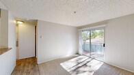 Located at 1700 Paseo Laguna Seco in Livermore, CA, this one-bedroom, one-bathroom unit offers a well-organized single-level layout designed for comfortable everyday living. The living room is bright and inviting, featuring plush carpeting, a textured ceiling, a baseboard heating system, and a wall-mounted air conditioning unit. A sliding glass door opens directly to a private balcony, filling the space with natural light and offering views of the surrounding hillside and mature trees. The galley-style kitchen is efficiently designed with white cabinetry, granite-look countertops, wood-look vinyl flooring, and black appliances including a range and refrigerator. A ceiling fan fixture accents the adjacent dining area, which continues the warm wood-look flooring. The bedroom is a comfortable, carpeted retreat with a window framing natural views, a baseboard heater, and access to a dedicated closet. The bathroom is clean and functional, featuring wood-look flooring, a granite-look vanity countertop with white cabinetry, and a full tub-shower combination. Throughout the unit, neutral tones and consistent finishes create a cohesive and practical living environment.