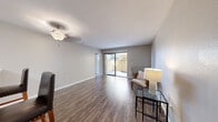 This 2-bedroom, 1-bathroom residence is thoughtfully laid out across a single floor, offering a functional and cohesive living experience. Rich wood-style flooring flows throughout the main living areas, creating a warm and consistent aesthetic.

The living room is generously proportioned, featuring a ceiling fan, neutral-toned walls, and a sliding glass door that fills the space with natural light and opens to a private outdoor patio. Adjacent to the living area, the kitchen is well-equipped with dark espresso cabinetry, white quartz-style countertops, stainless steel appliances including a gas range and microwave, and a tasteful tile backsplash. A breakfast bar with seating provides a convenient casual dining option.

Both bedrooms are carpeted and finished with neutral tones, ceiling fans, and natural light from exterior windows. The primary bedroom is notably spacious and includes a mirrored closet. The shared bathroom continues the dark cabinetry theme with a wide vanity, white countertop, and wood-style flooring. A dedicated closet and two hallways provide additional storage and connectivity throughout the home. The overall ambiance is clean, modern, and move-in ready.