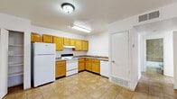 Located at 12121 Pellicano Dr in El Paso, TX, this single-floor unit offers a functional and practical layout with two bedrooms, one bathroom, and a dedicated living area. The kitchen is designed in an L-shape and features warm honey-toned oak cabinetry, laminate countertops, and durable tile flooring. It is fully equipped with a white electric range, refrigerator, and dishwasher, along with ample upper and lower cabinet storage and an open pantry area. The living room is carpeted and features a neutral grey accent wall, providing a versatile backdrop for furnishings. The primary bedroom is comfortably sized and includes a ceiling fan with light fixture, sliding glass door access with vertical blinds that invite natural light, and soft carpet underfoot. The second bedroom is bright with a window fitted with blinds, also finished in carpet. Both bedrooms include dedicated closets. The bathroom is finished with large-format beige tile on the floors and surrounding the tub/shower enclosure, complemented by an oak vanity cabinet and a full soaking tub. The unit's clean, neutral palette and practical finishes make it a move-in ready home.